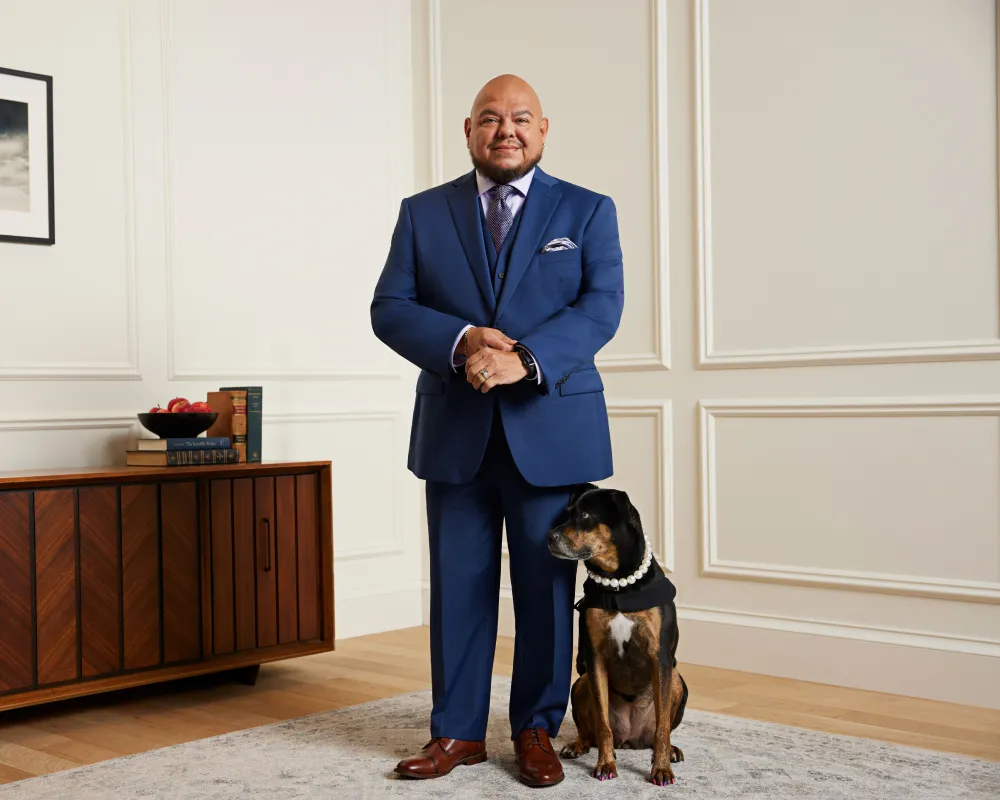 Man wearing a suit with his dog at an event